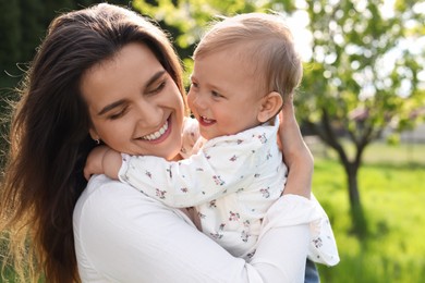 Photo of Happy mother with her cute baby in park on sunny day