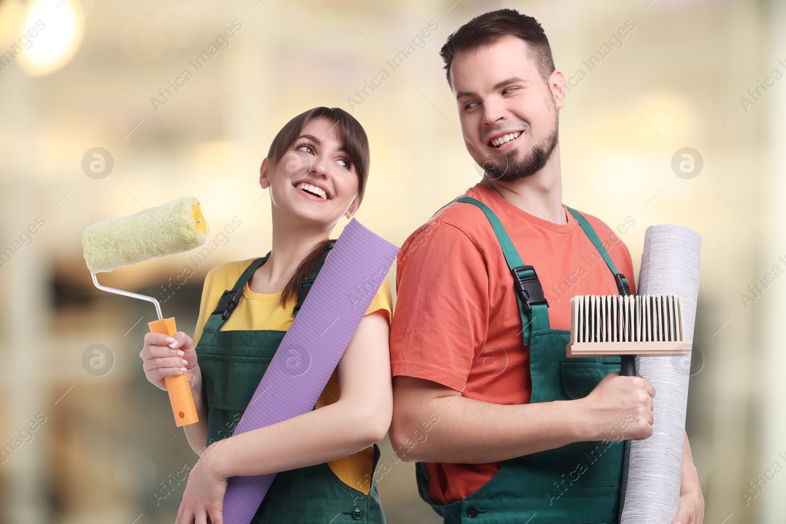 Image of Workers with wallpaper rolls and tools indoors