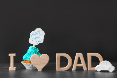 Phrase "I love dad" and cupcake on table. Father's day celebration