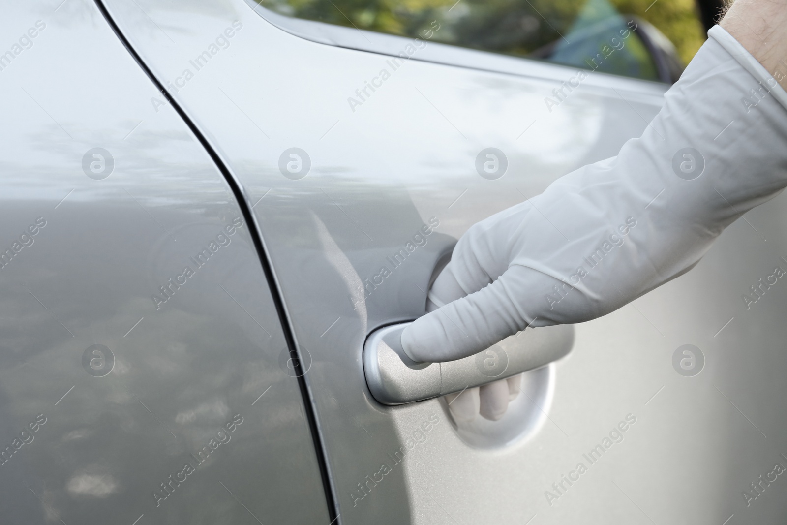 Photo of Closeup view of man in glove opening car door