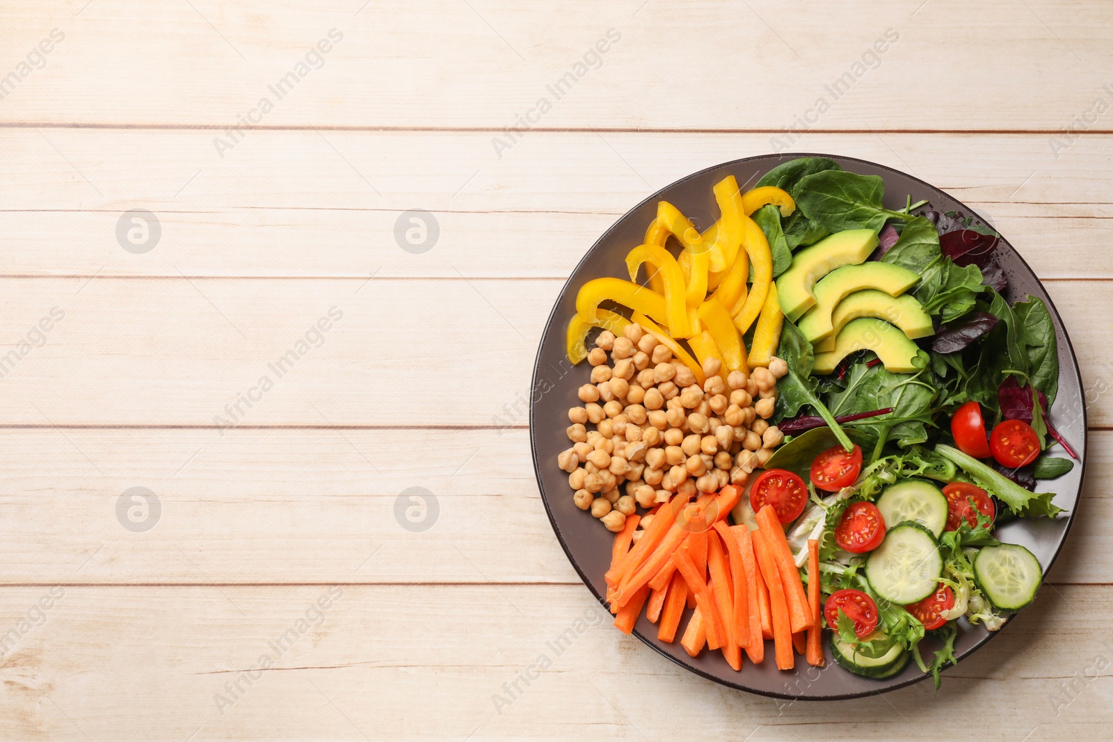 Photo of Balanced diet and vegetarian foods. Plate with different delicious products on wooden table, top view. Space for text