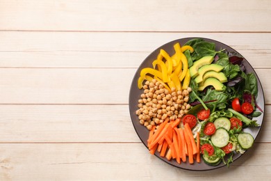 Balanced diet and vegetarian foods. Plate with different delicious products on wooden table, top view. Space for text