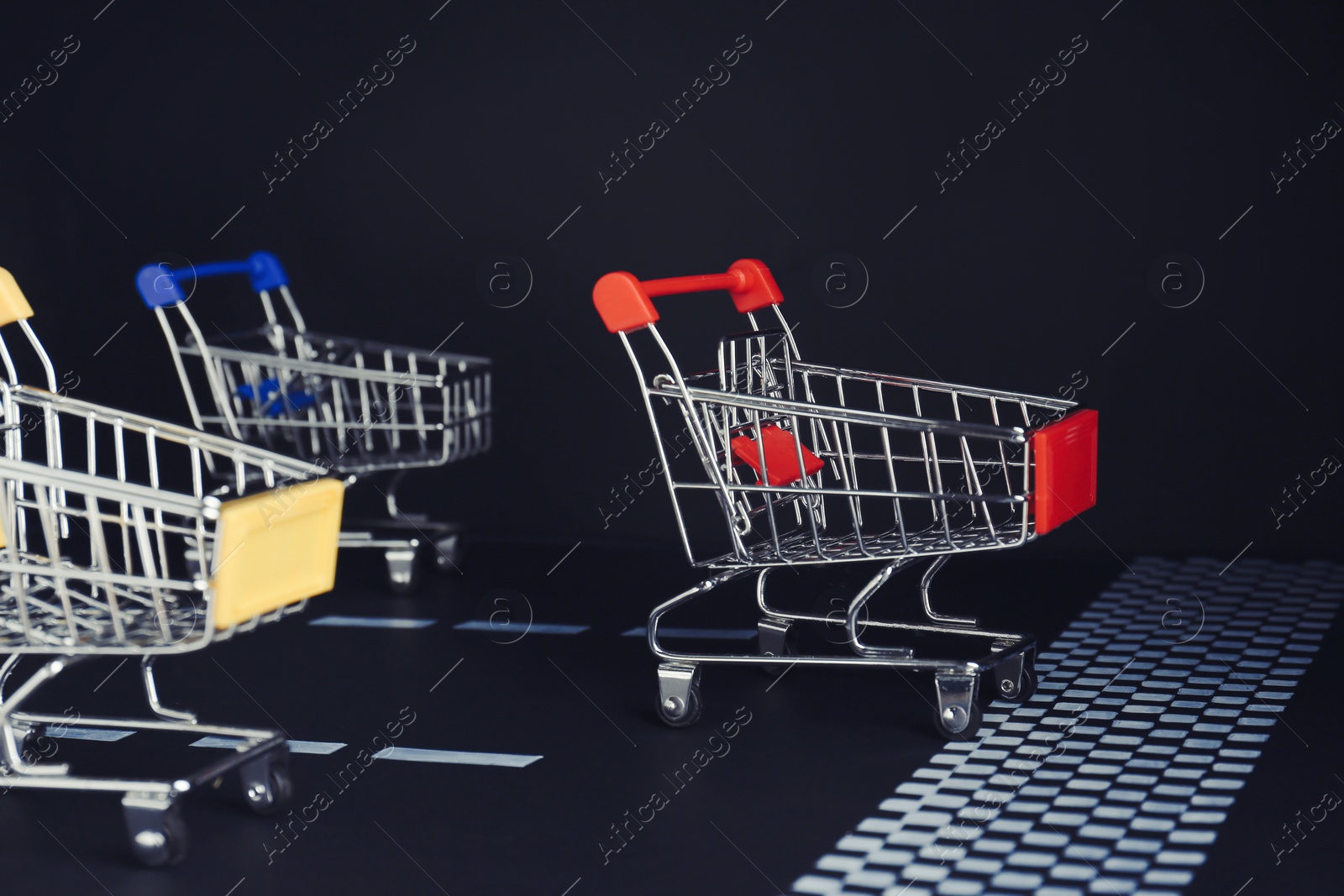 Photo of Competition concept. Shopping carts racing towards finish line