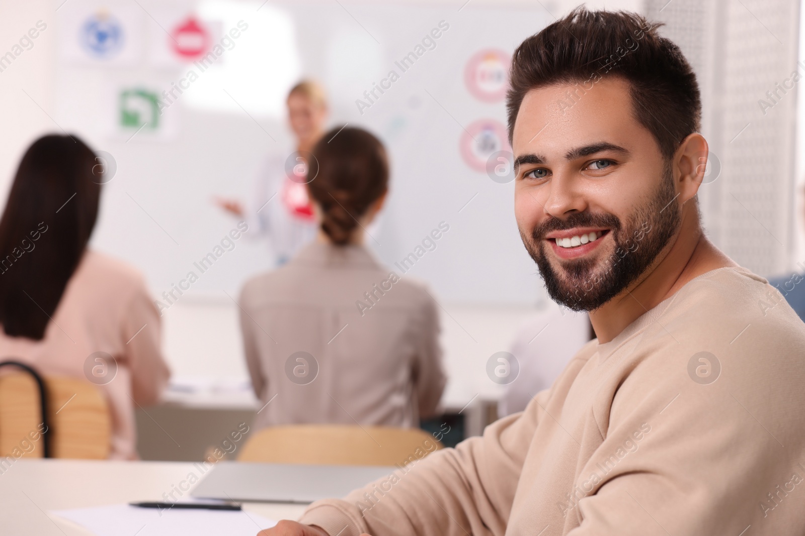 Photo of Happy man at desk in class during lesson in driving school. Space for text