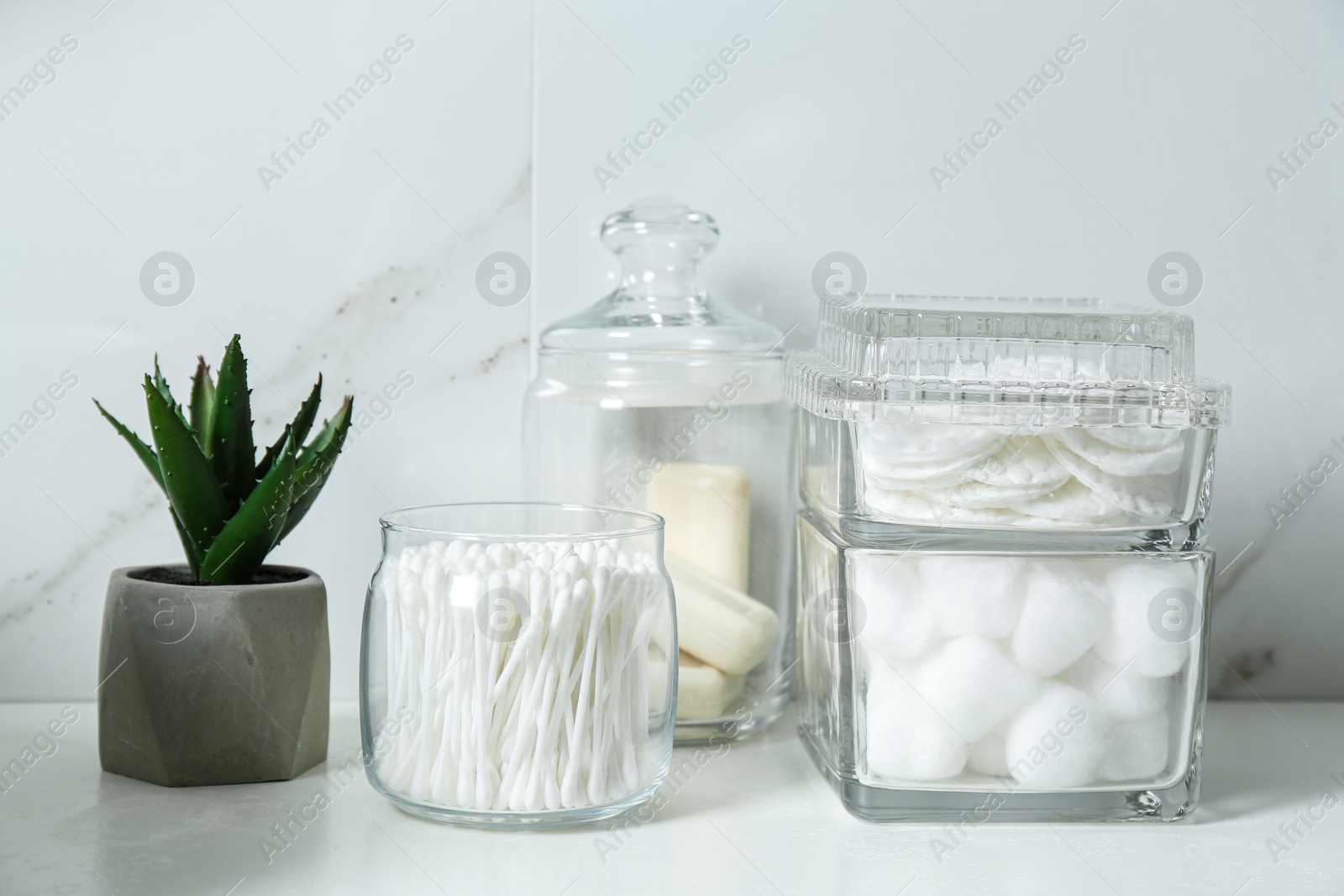 Photo of Cotton swabs, pads and balls on white countertop in bathroom