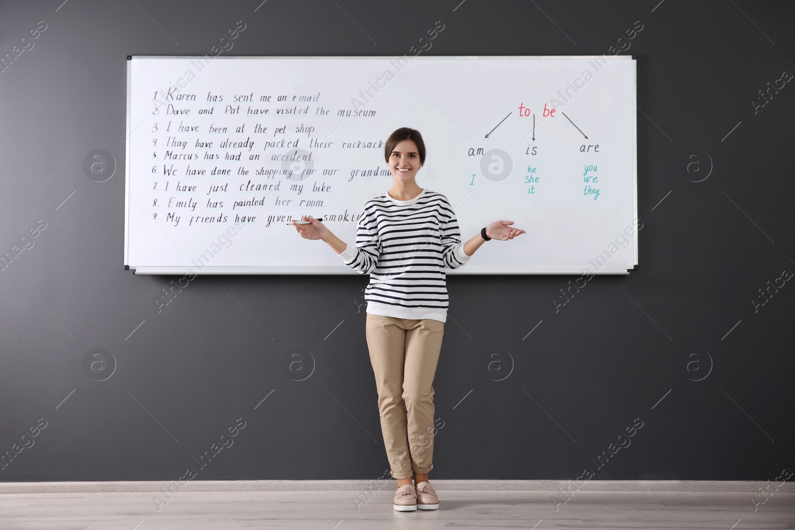 Photo of Happy English teacher near whiteboard at lesson