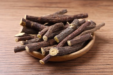 Dried sticks of liquorice root on wooden table, closeup