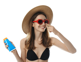 Young woman applying sun protection cream on white background