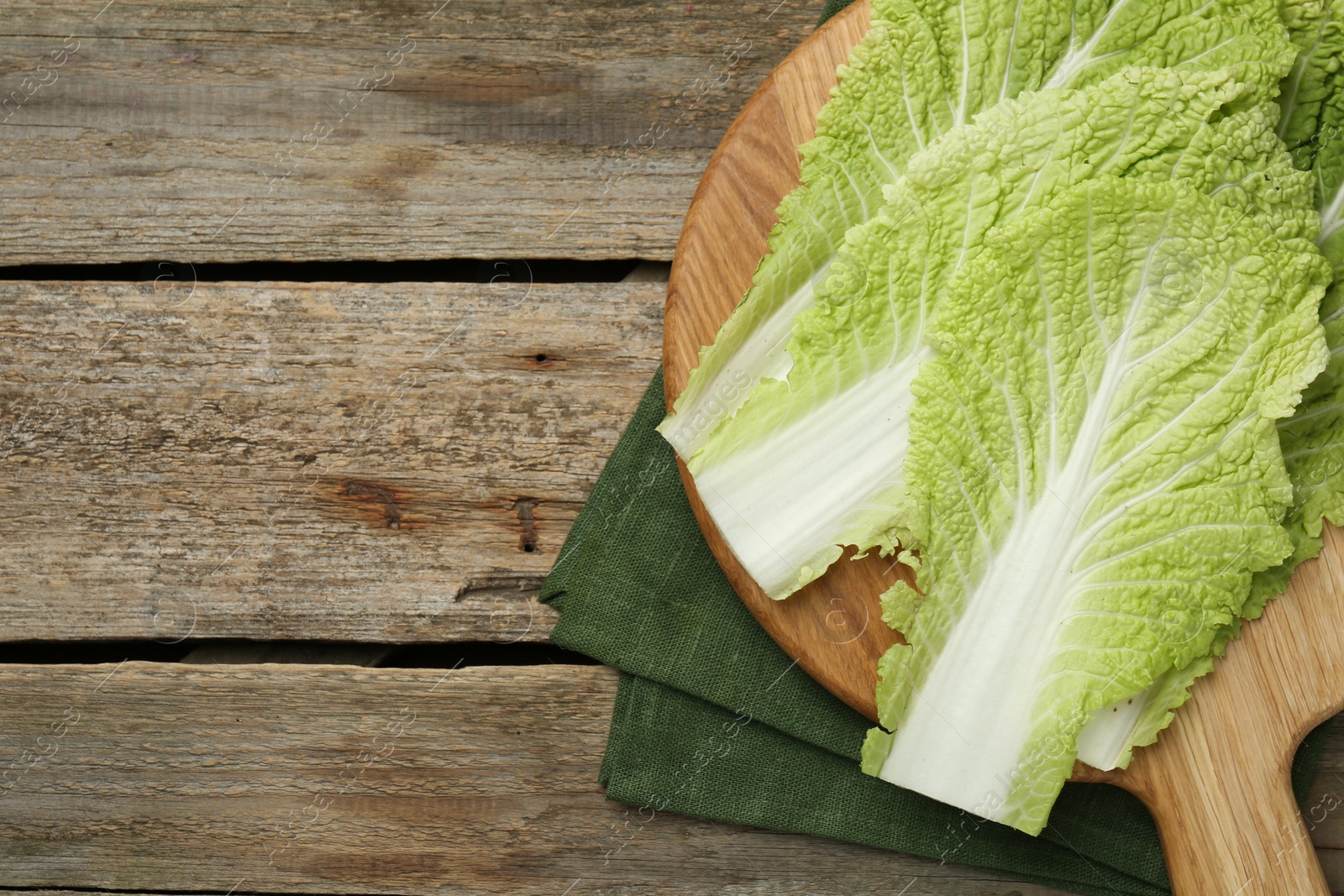 Photo of Fresh leaves of Chinese cabbage on wooden table, top view, Space for text