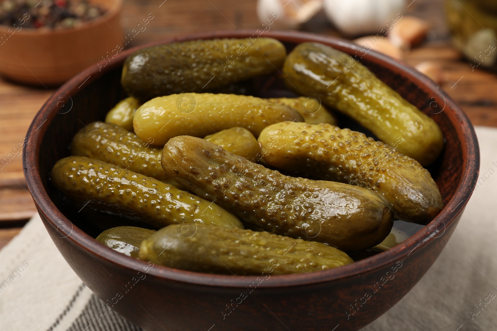 Photo of Tasty pickled cucumbers in bowl on table, closeup