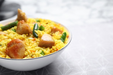 Photo of Delicious rice pilaf with meat served on table, closeup. Space for text
