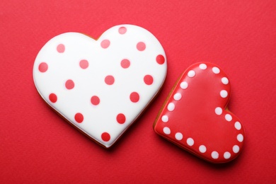 Photo of Decorated heart shaped cookies on red background, flat lay. Valentine's day treat