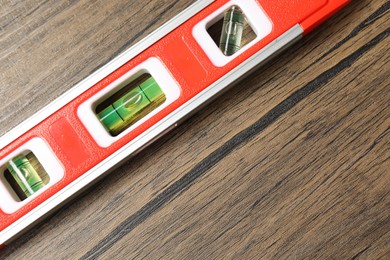 Photo of One red building level on wooden table