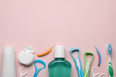 Photo of Tongue cleaners and other oral care products on pink background, flat lay. Space for text