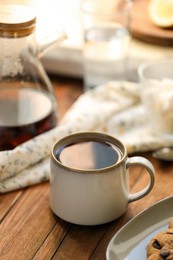 Photo of Mug with delicious tea on wooden table
