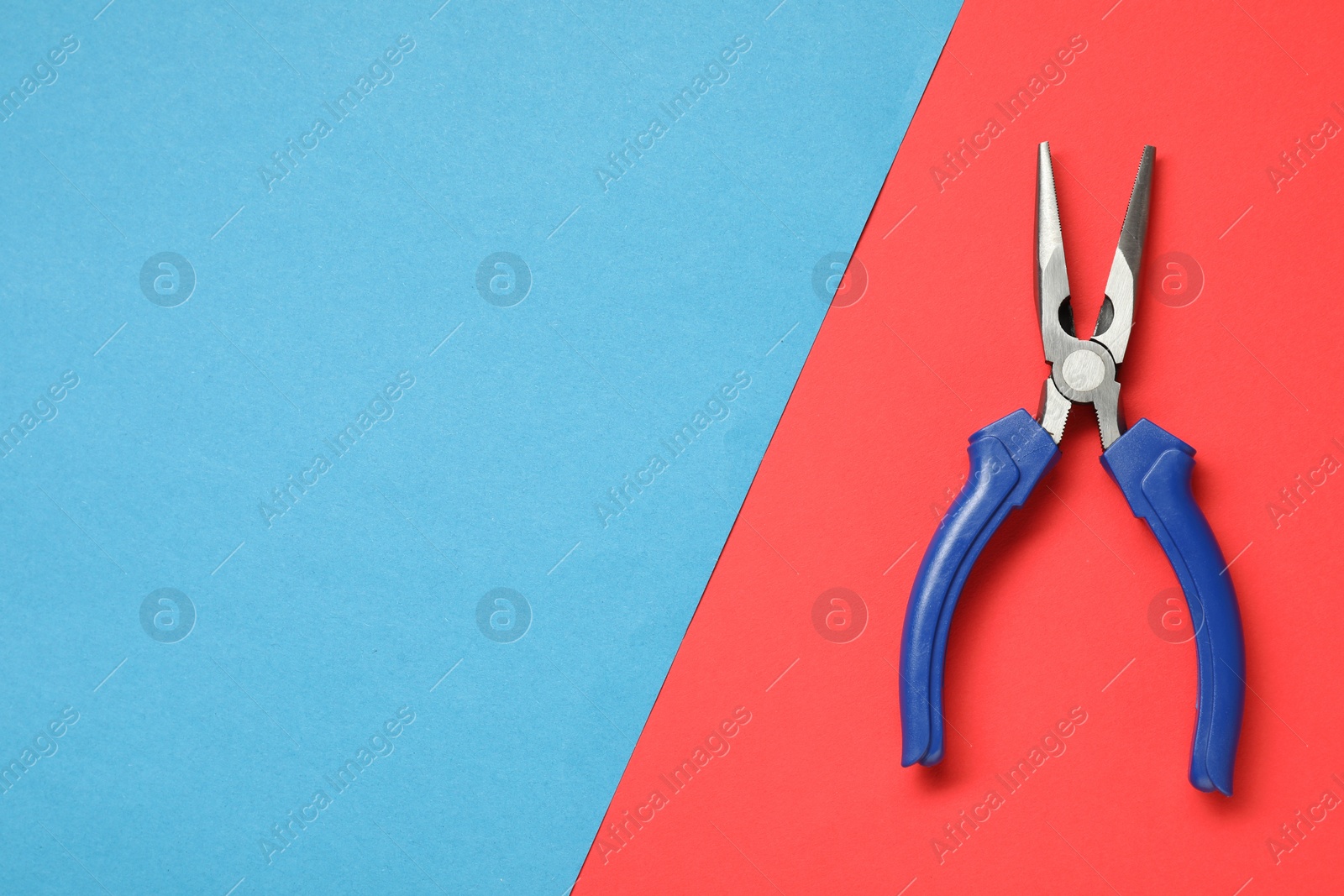 Photo of Needle nose pliers on color background, top view. Space for text