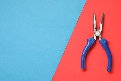 Photo of Needle nose pliers on color background, top view. Space for text