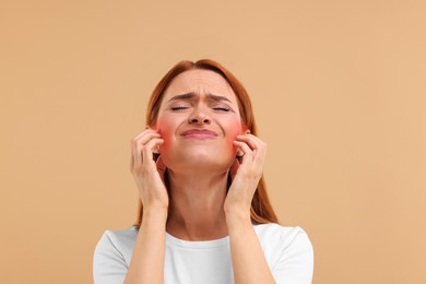 Suffering from allergy. Young woman scratching her face on beige background
