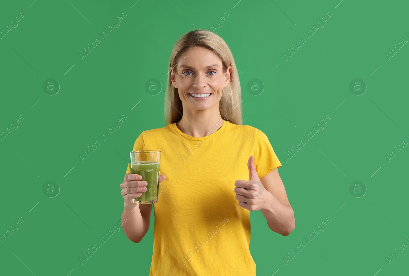 Photo of Woman with glass of tasty celery juice on green background