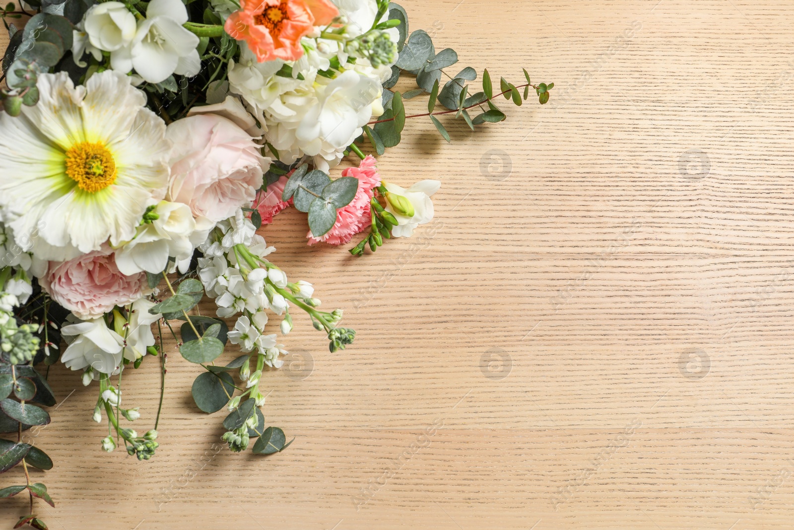 Photo of Bouquet of beautiful flowers on wooden table, above view. Space for text