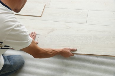 Man installing new laminate flooring, closeup view