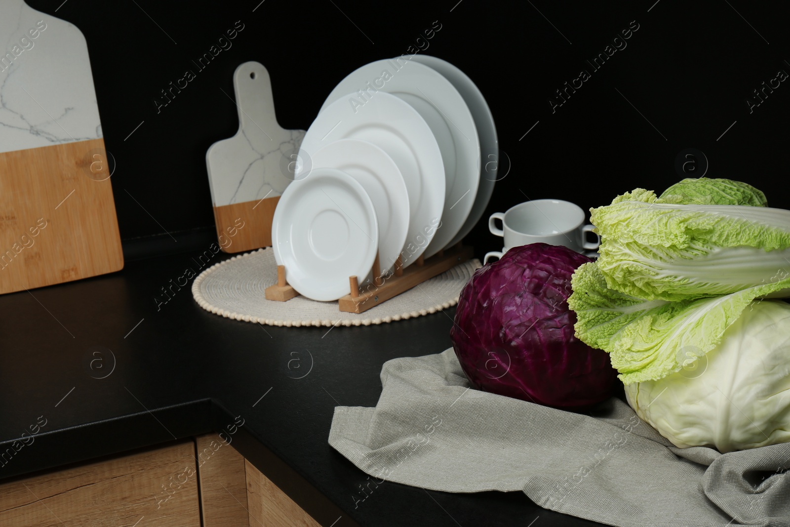 Photo of Different types of cabbage on countertop in kitchen