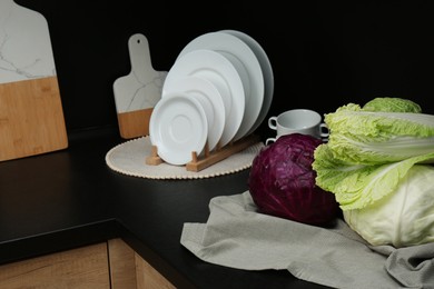 Different types of cabbage on countertop in kitchen