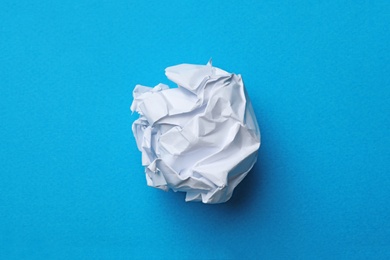 Crumpled sheet of paper on color background, top view