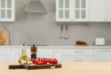 Photo of Fresh cherry tomatoes, oil, garlic and peppercorns on wooden table in kitchen. Space for text