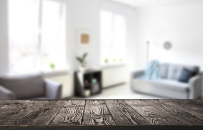 Empty wooden surface and blurred view of room with modern windows