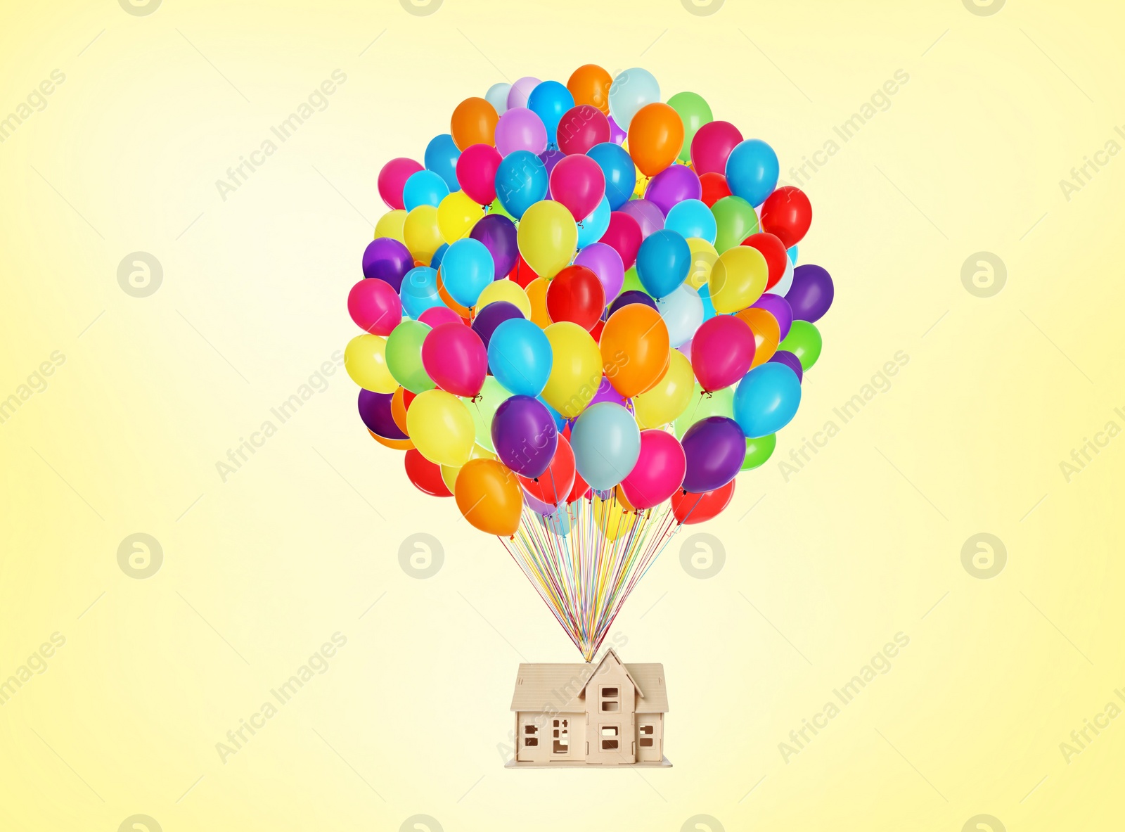 Image of Many balloons tied to model of house flying on yellow background