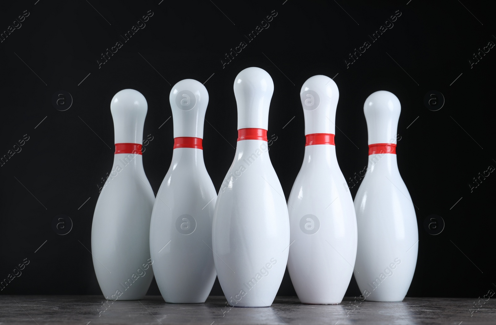 Photo of Set of bowling pins on grey stone table