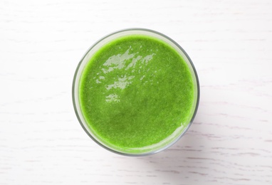 Delicious fresh green juice on white wooden table, top view