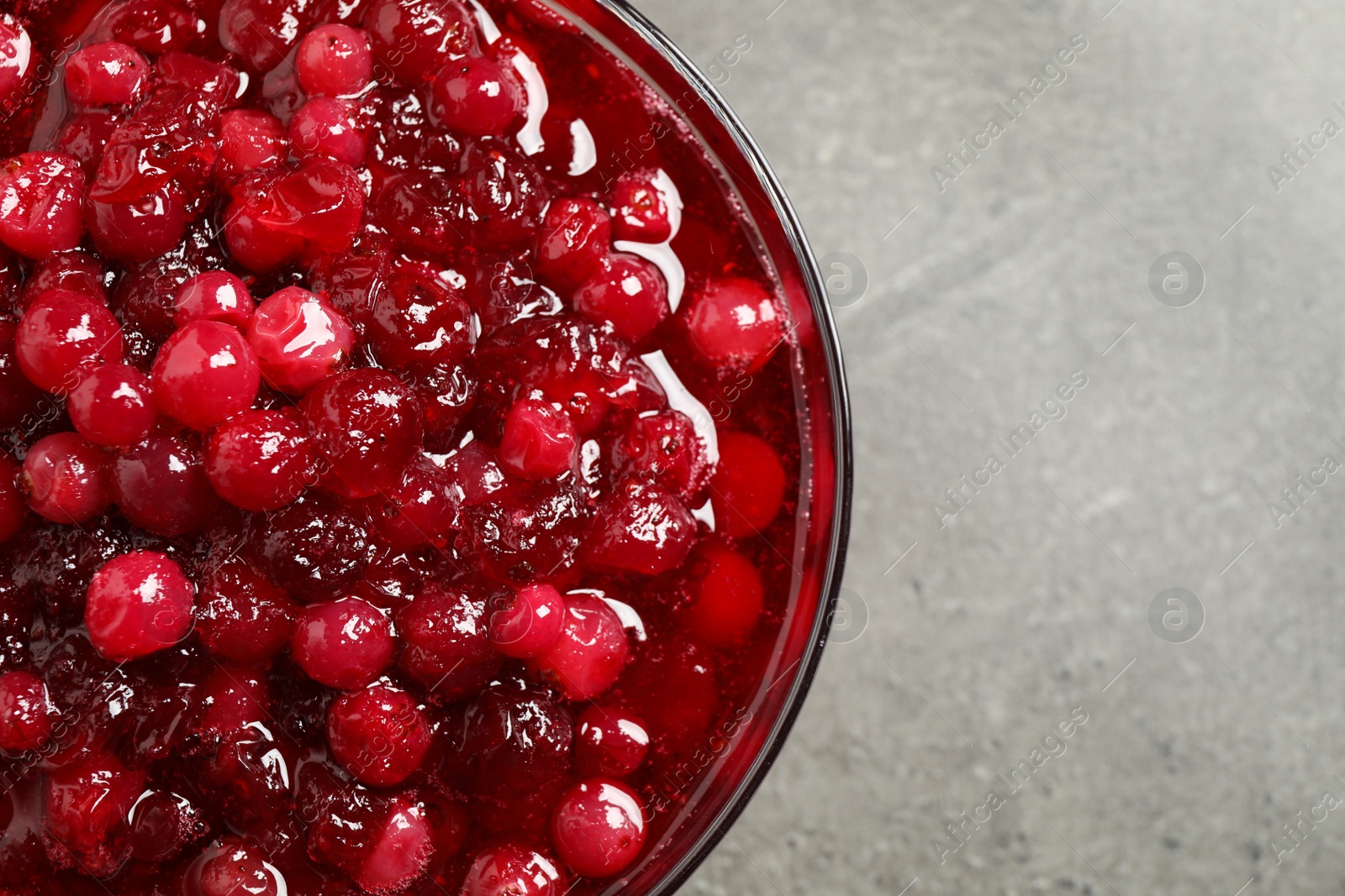 Photo of Fresh cranberry sauce on grey table, closeup
