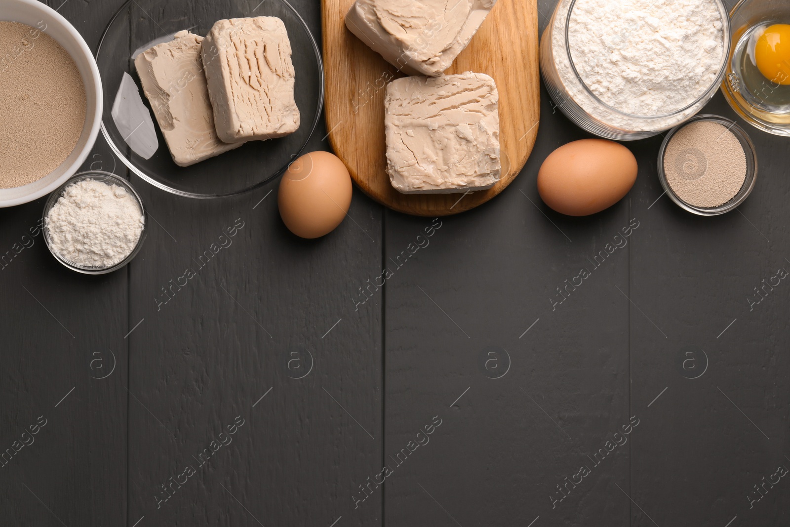 Photo of Different types of yeast, eggs and flour on grey wooden table, flat lay. Space for text