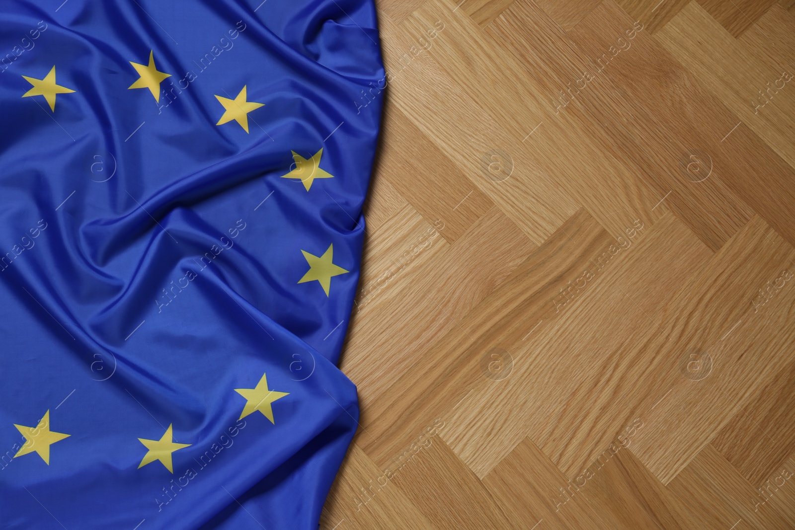 Photo of Flag of European Union on wooden table, top view. Space for text