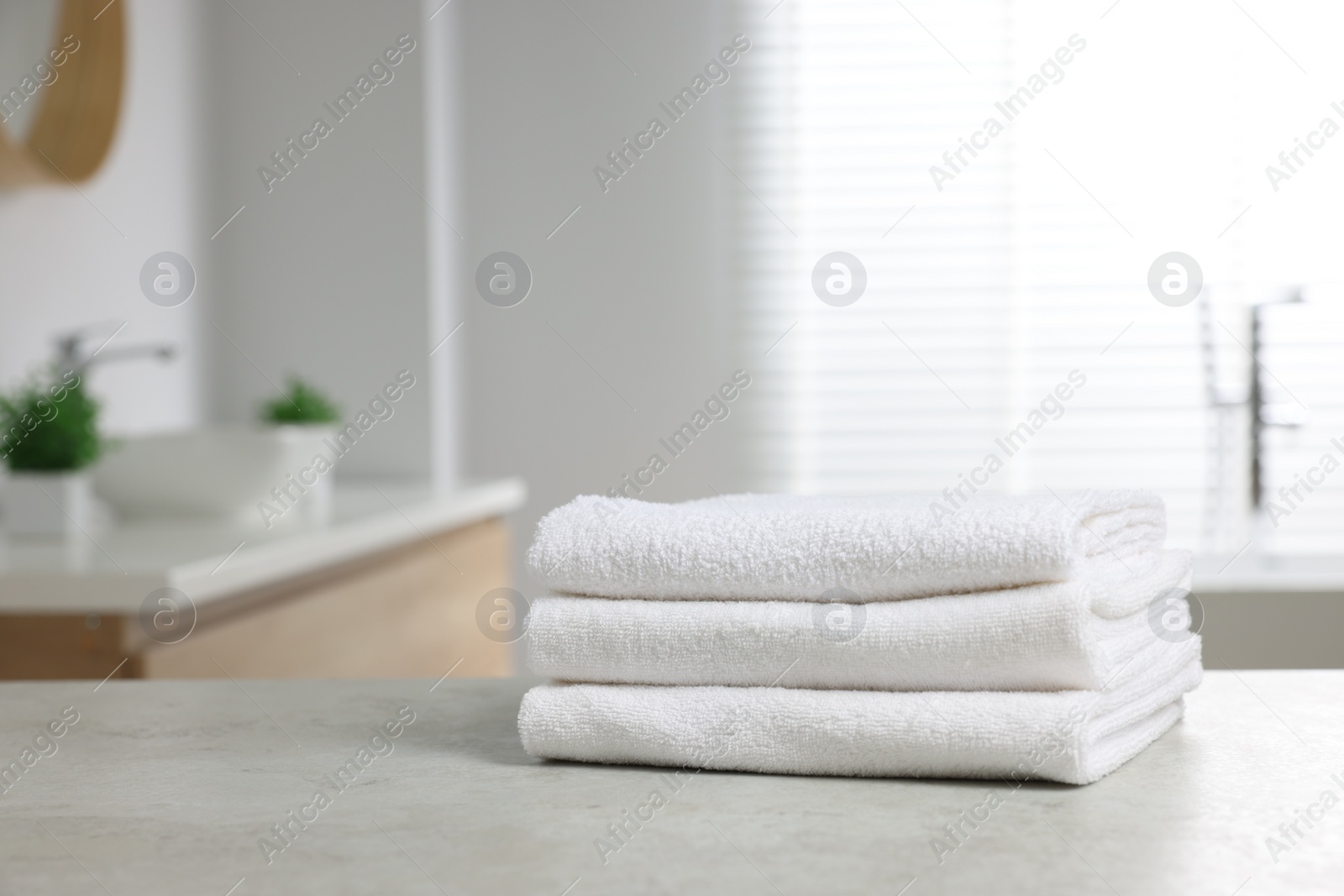 Photo of Stack of white towels on table in bathroom. Space for text