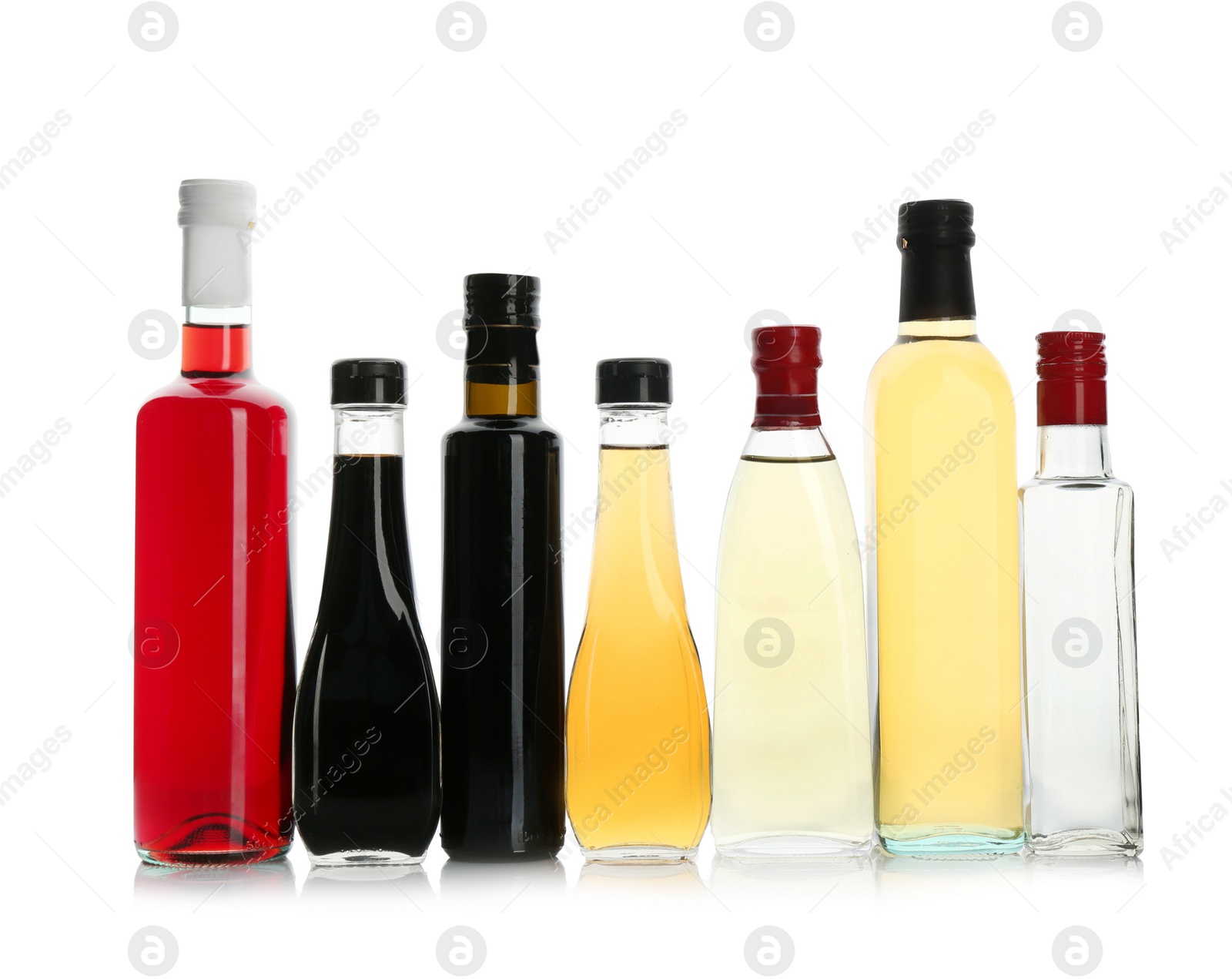 Photo of Bottles with different kinds of vinegar on white background