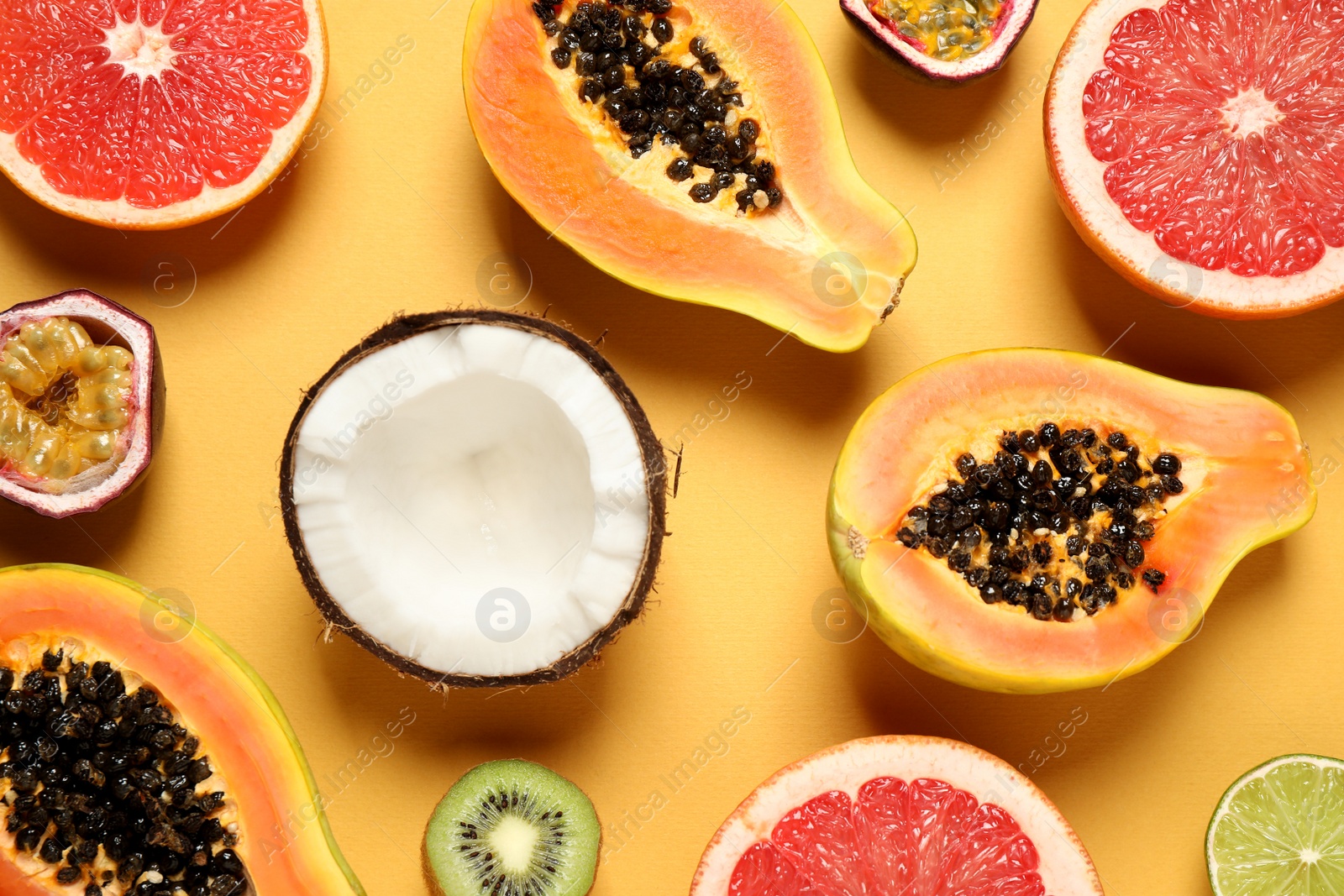 Photo of Fresh ripe papaya and other fruits on yellow background. flat lay