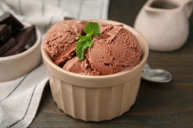 Bowl of tasty chocolate ice cream on wooden table, closeup