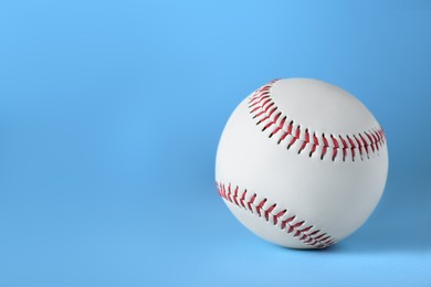 Baseball ball on light blue background, closeup with space for text. Sports game