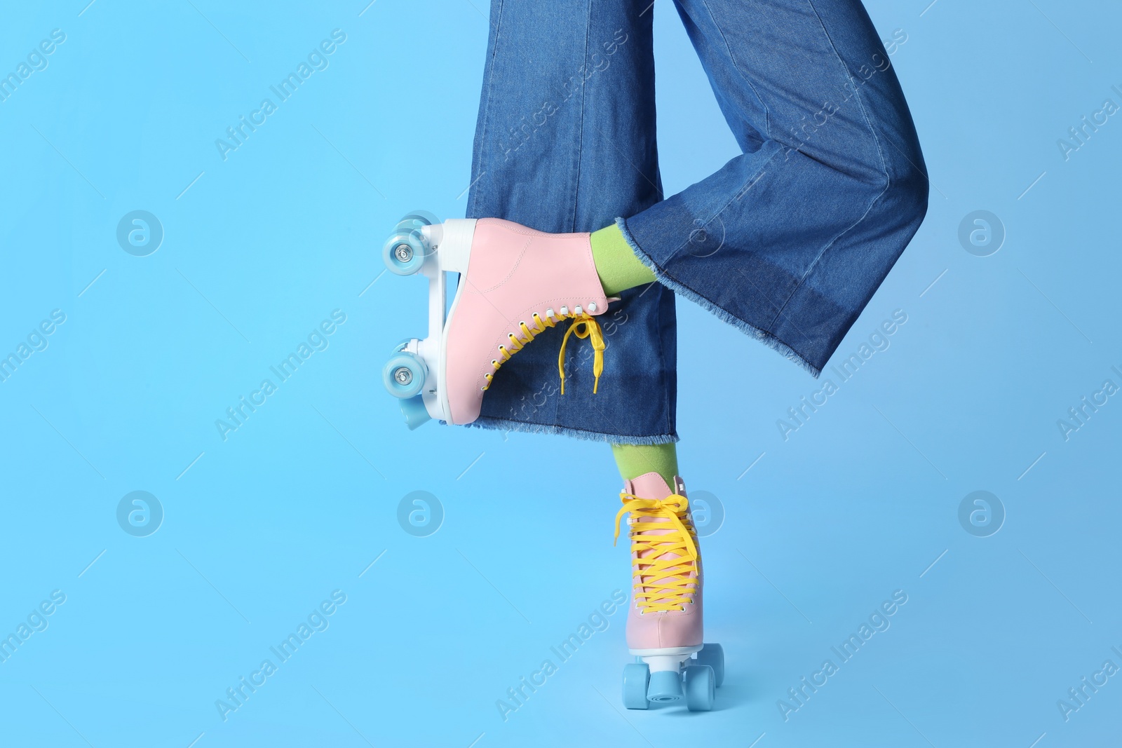 Photo of Woman with vintage roller skates on color background, closeup. Space for text