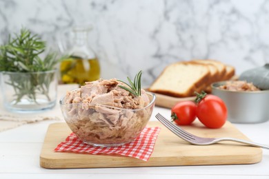 Photo of Bowl with canned tuna and rosemary on white wooden table