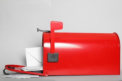Photo of Open red letter box with envelopes on light background, closeup