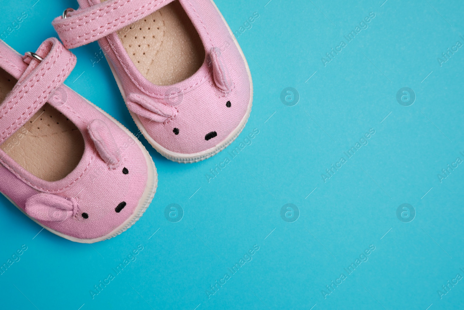 Photo of Cute baby shoes on light blue background, flat lay. Space for text