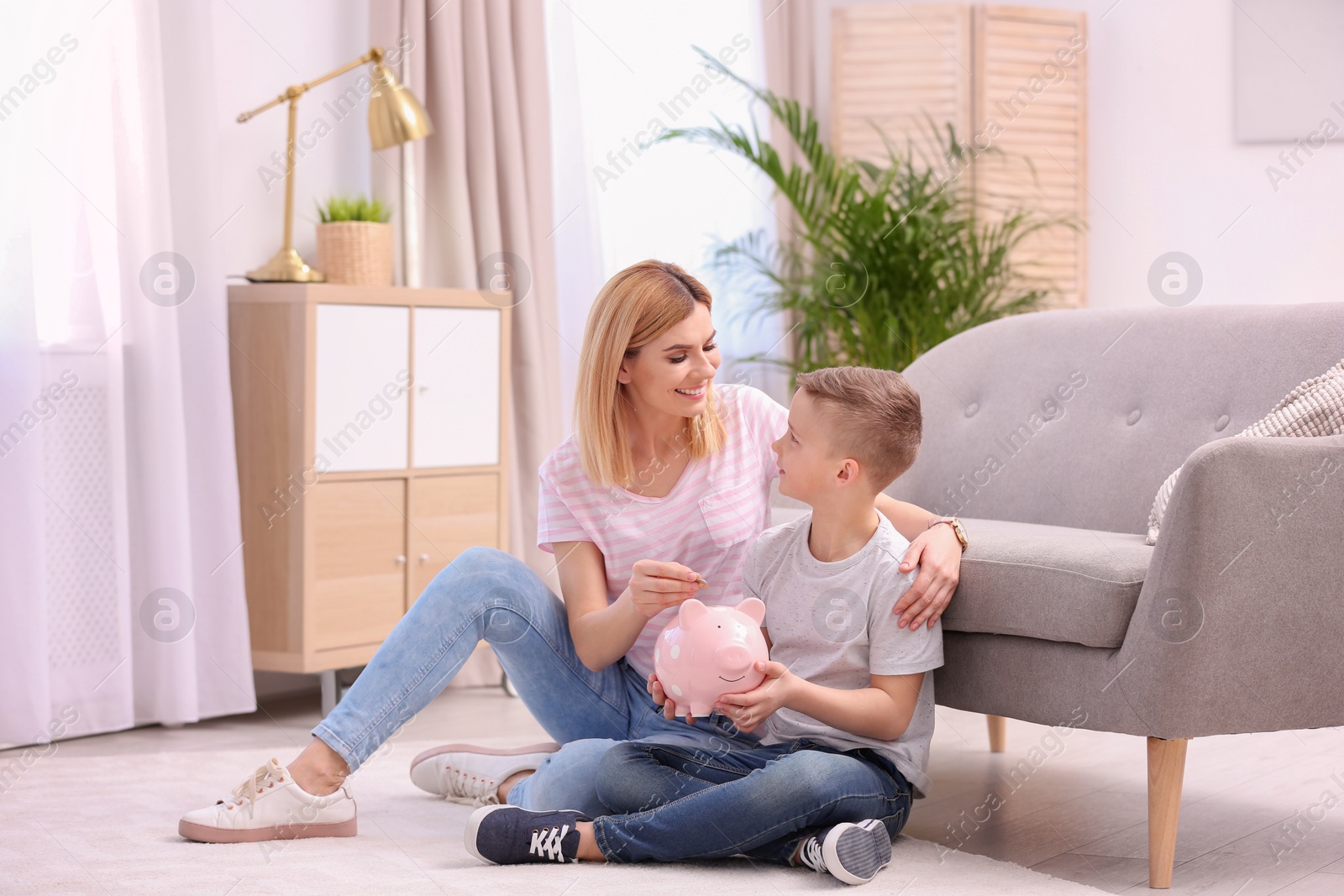 Photo of Family with piggy bank and money at home. Space for text