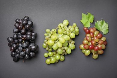 Photo of Different fresh ripe juicy grapes on color background, top view