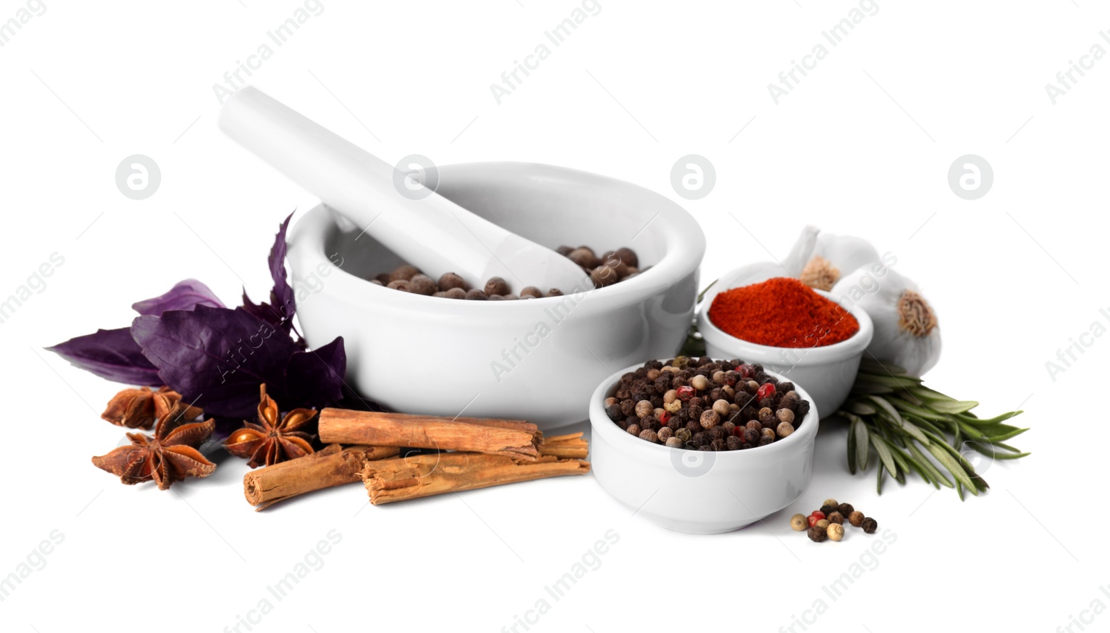 Photo of Mortar with pestle and different spices on white background