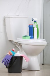Cleaning supplies and toilet bowl in bathroom
