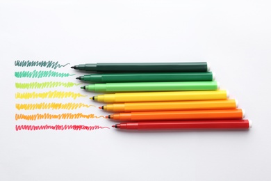 Photo of Flat lay composition with colorful markers on white background. Energy efficiency concept